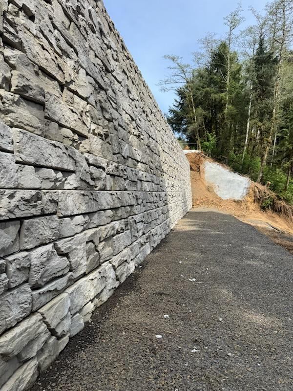 Tall Verti-Block wall beside a gravel access road at the Highway 101 slope repair
