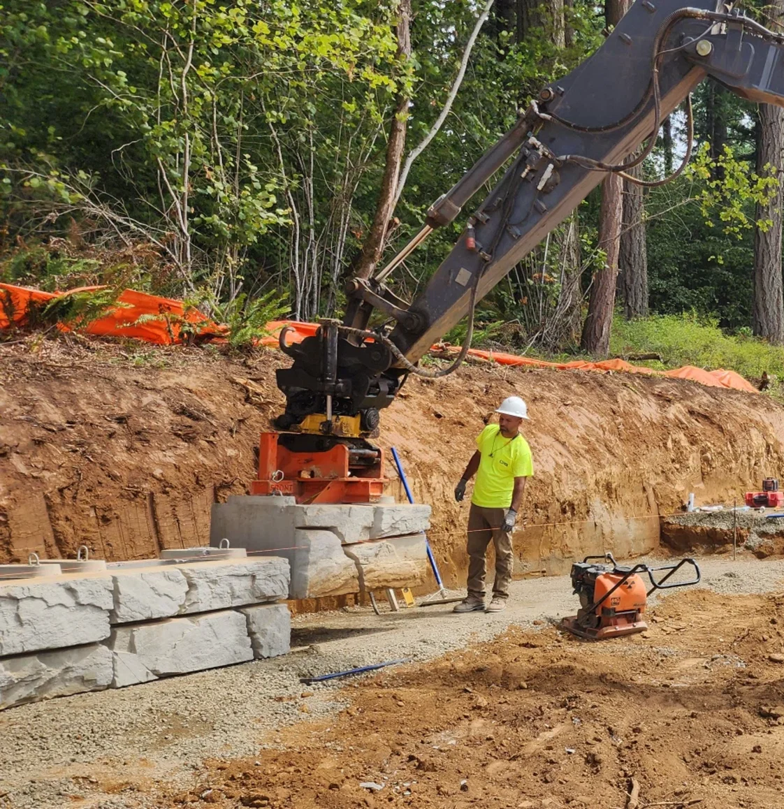 Crew compacting backfill behind the wall