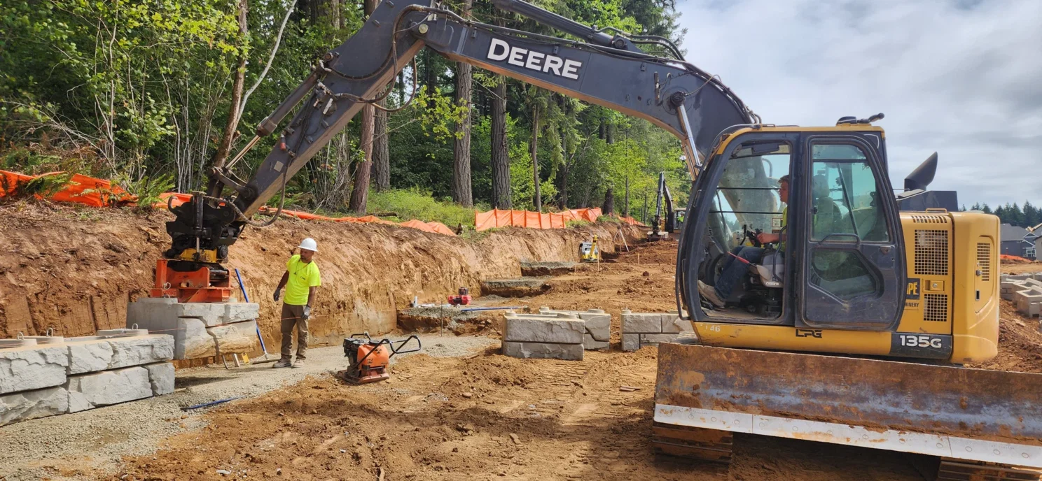 Crew excavating and preparing the wall base